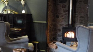 A cozy room with a stone fireplace, a television, and comfortable seating.