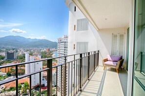 A balcony with a view of a cityscape and mountains.