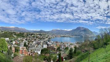 Une vue panoramique d’une ville avec un lac, des montagnes et un ciel dégagé.