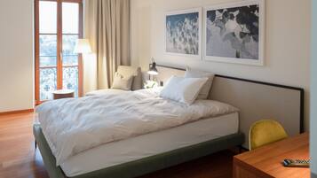 Ein Hotelzimmer mit Bett, Stuhl, Tisch und einem Vorhangfenster.