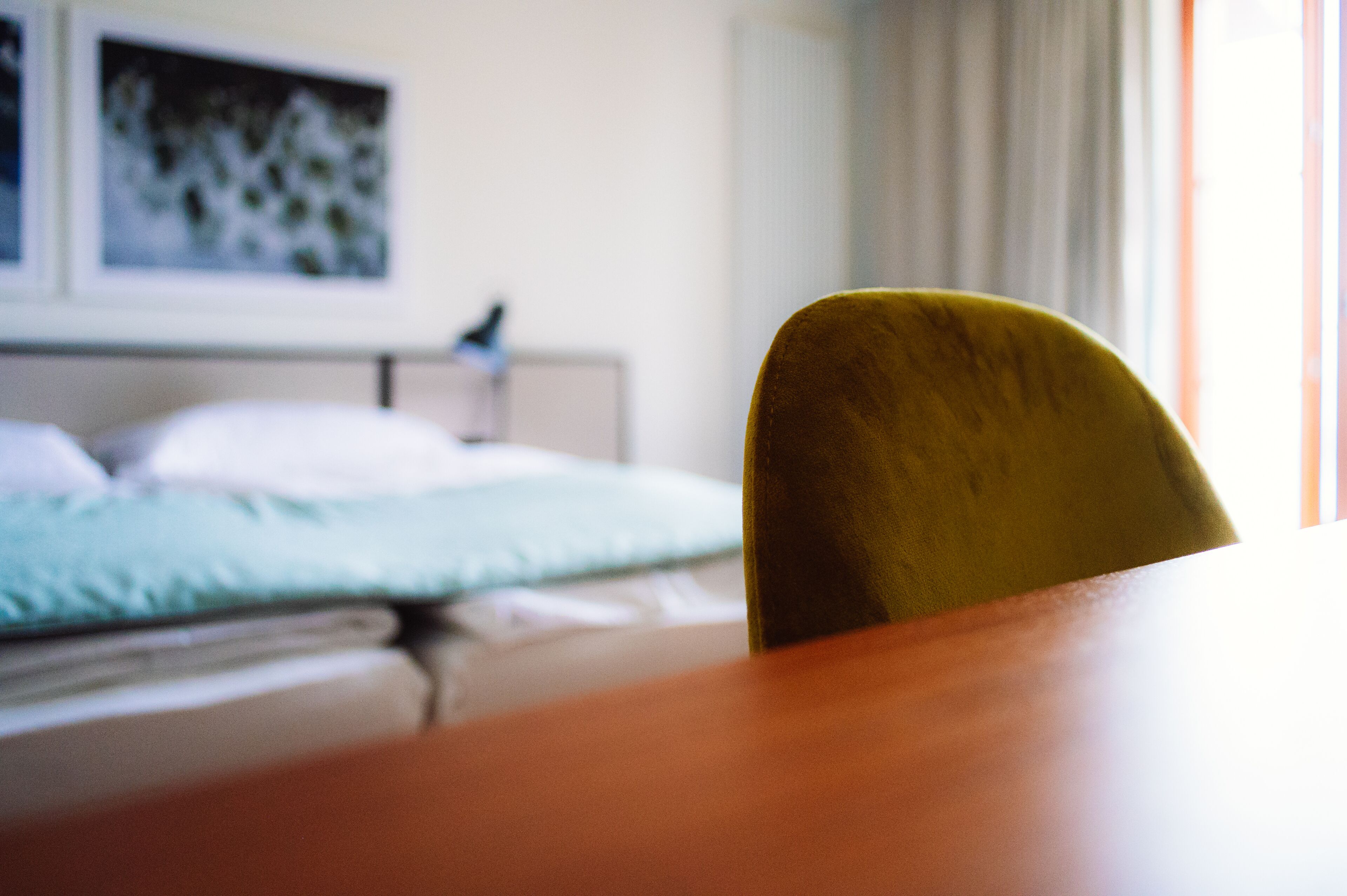 Une chambre avec un lit, une table de chevet et une chaise.