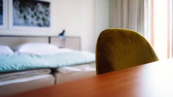 Ein Zimmer mit einem Bett, einem Nachttisch und einem Sessel.