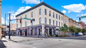 A historic building with a classic architectural style, featuring a central entrance with a covered awning, located at a street corner. - Broughton Retreat in the Heart of Downtown! (Savannah)