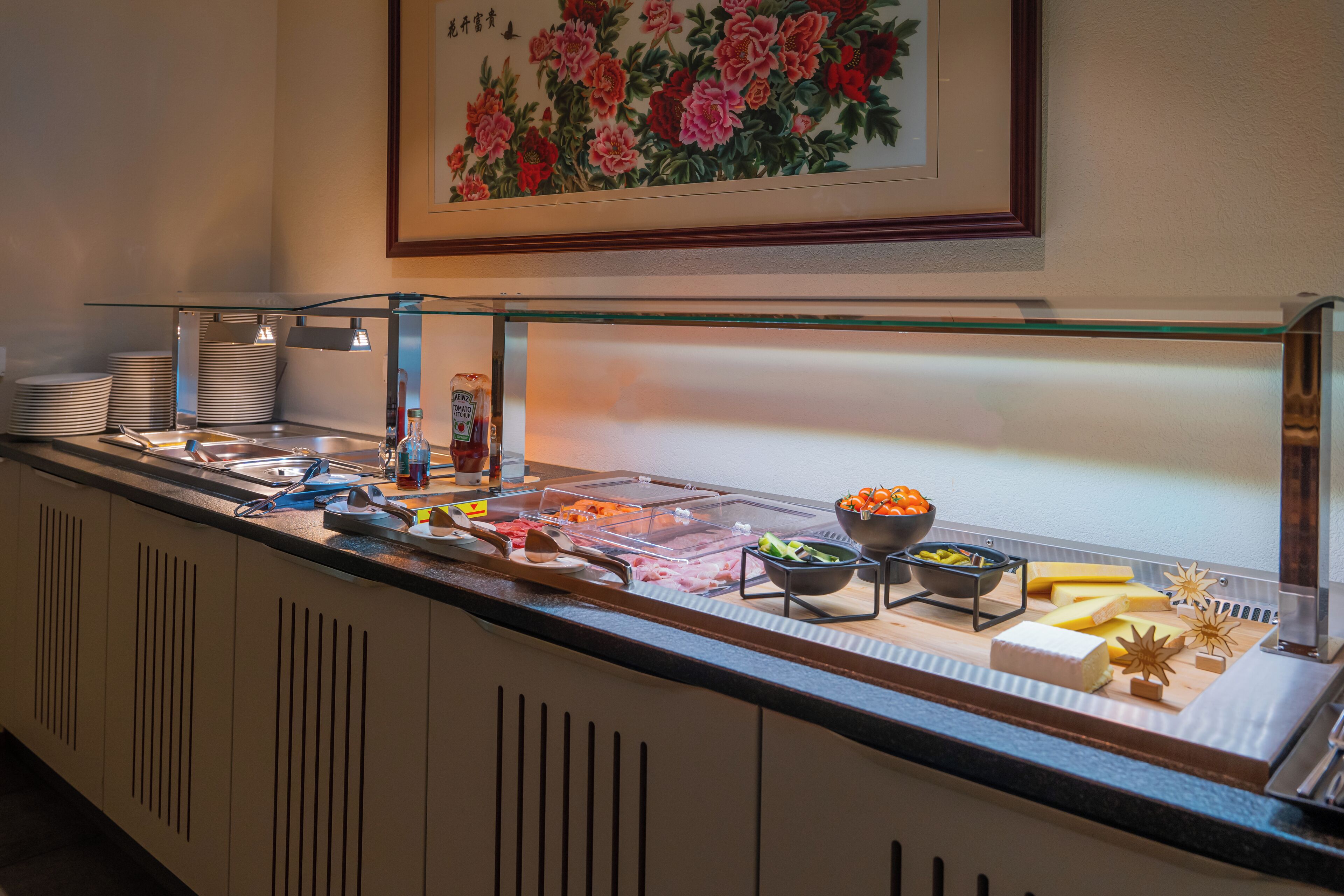A buffet with various food items, including meats, cheeses, and vegetables.