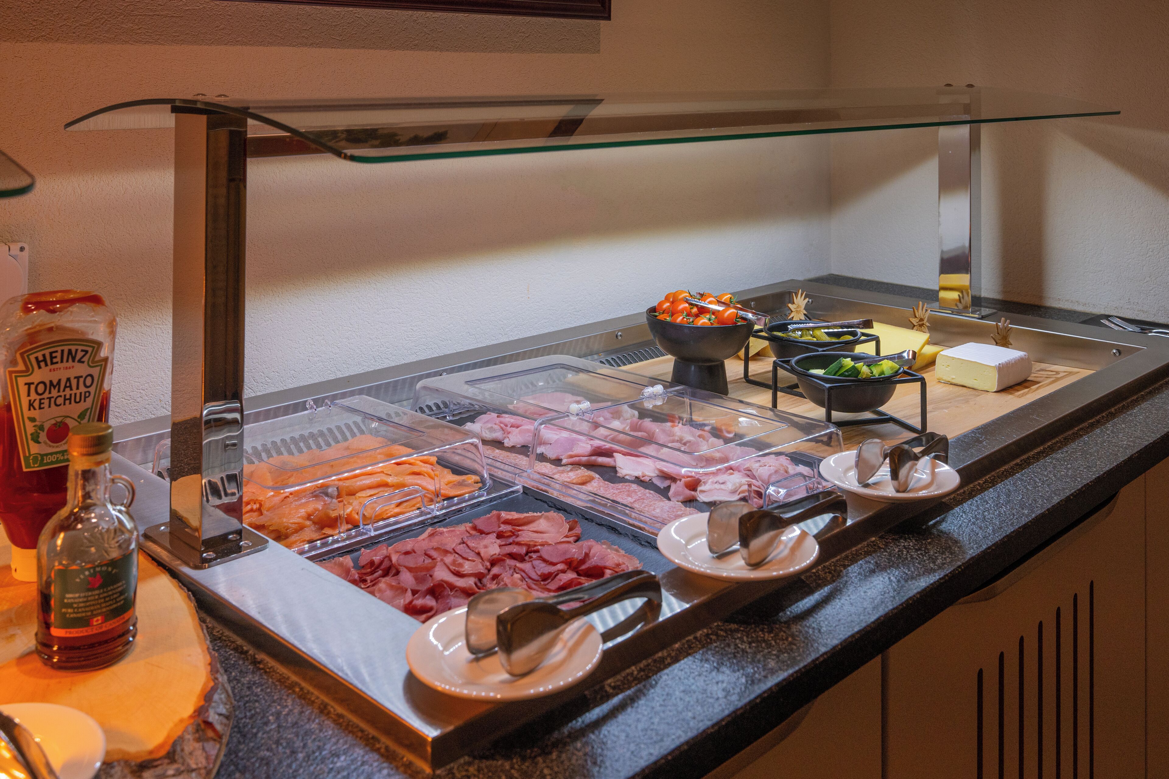 Ein Buffet mit verschiedenen Fleisch-, Käse- und Wurstwaren sowie Beilagen.