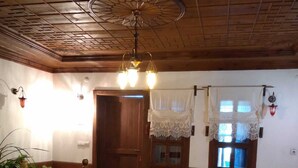 A cozy room with wooden flooring, a patterned rug, a bench, and a door. - Safranbolu Konagi (Safranbolu)