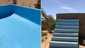 Una piscina con revestimiento azul y estructura de hormigón con escalones de acceso.
