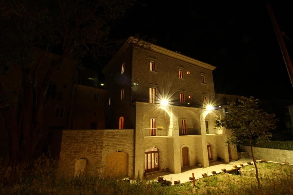 A multi-story building with a stone facade, arched windows, and a central courtyard.