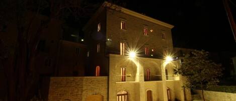 A multi-story building with a stone facade, arched windows, and a central courtyard.