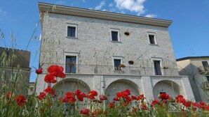 A stone building with multiple windows and arched doorways. - Palazzo 1892 (Castelvetere in Val Fortore)