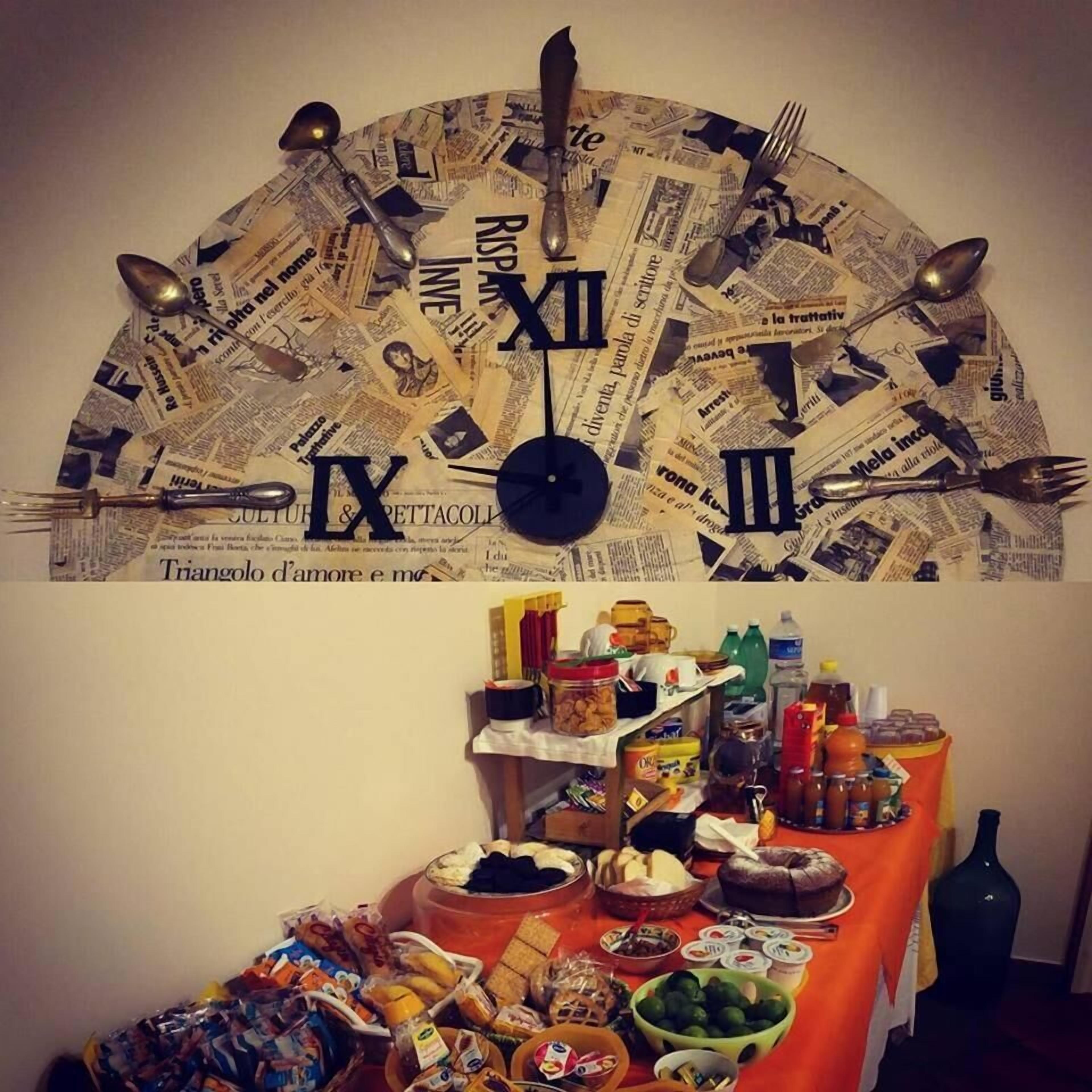 A wall clock made of newspaper clippings with a table of snacks and condiments below.