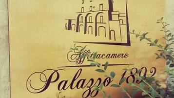 Una placa con una ilustración de un edificio y el texto 'Palazzo 1802'.