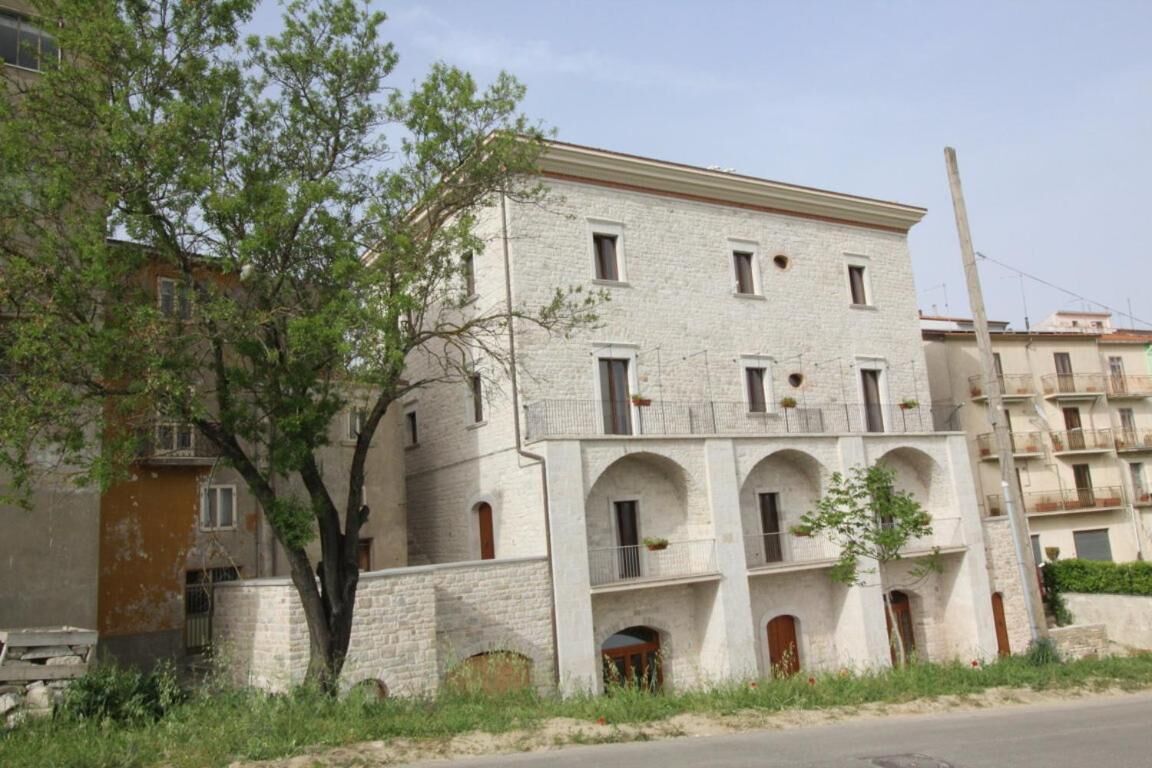 Un immeuble à plusieurs étages, doté d’une façade en pierre, de fenêtres en arc de cercle et de balcons.