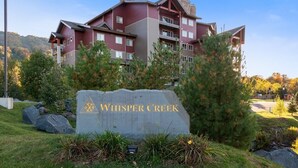 Un immeuble à plusieurs étages sur lequel on peut lire l’inscription « Whisper Creek ».