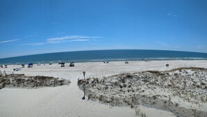 A beach with a sandy shore, a wooden fence, and the ocean in the background. - Perfect for quite Beach Lovers. Four pools.Fall/Off Season Week-Month Specials!
 (Orange Beach)