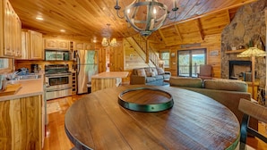 Una cabaña de madera espaciosa con cocina, comedor y sala de estar.
