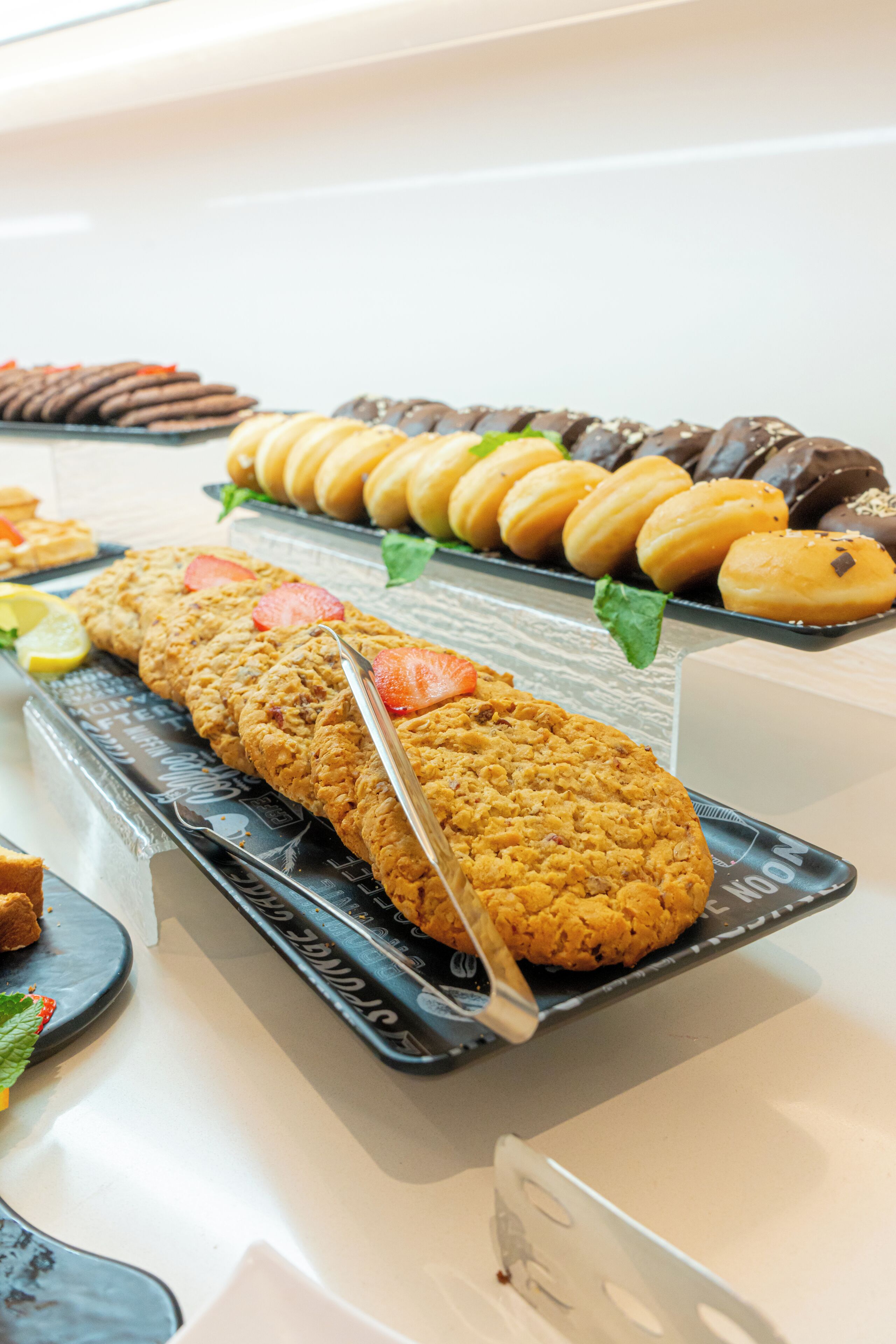 Een buffet met diverse gebakken lekkernijen, waaronder koekjes, gebak en chocolade.