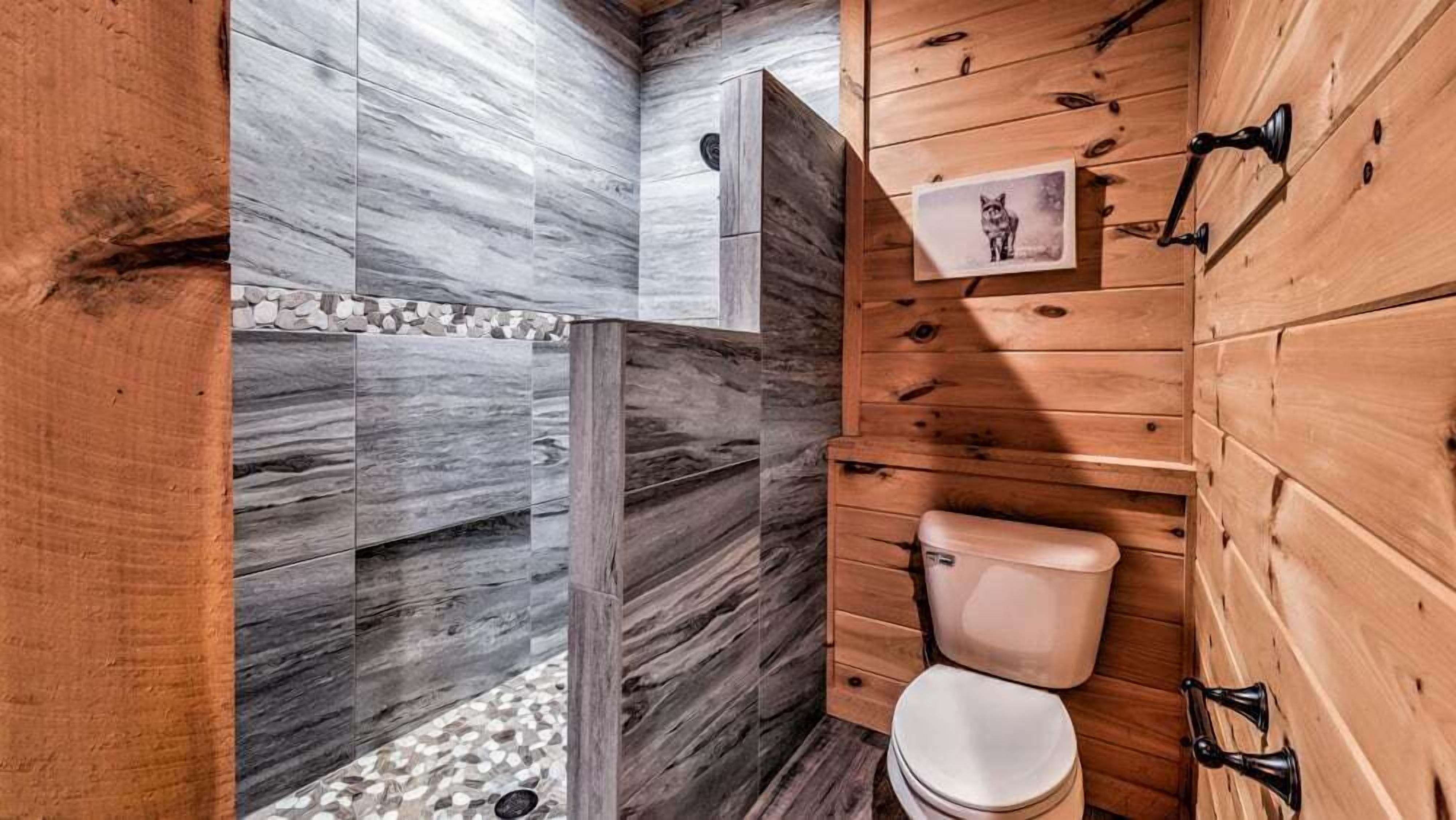 Een badkamer met een houten inrichting, een marmeren wand en een toilet.