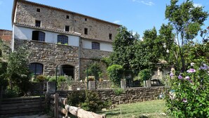 Un bâtiment en pierre doté de nombreuses fenêtres et d’une clôture en bois à l’avant.