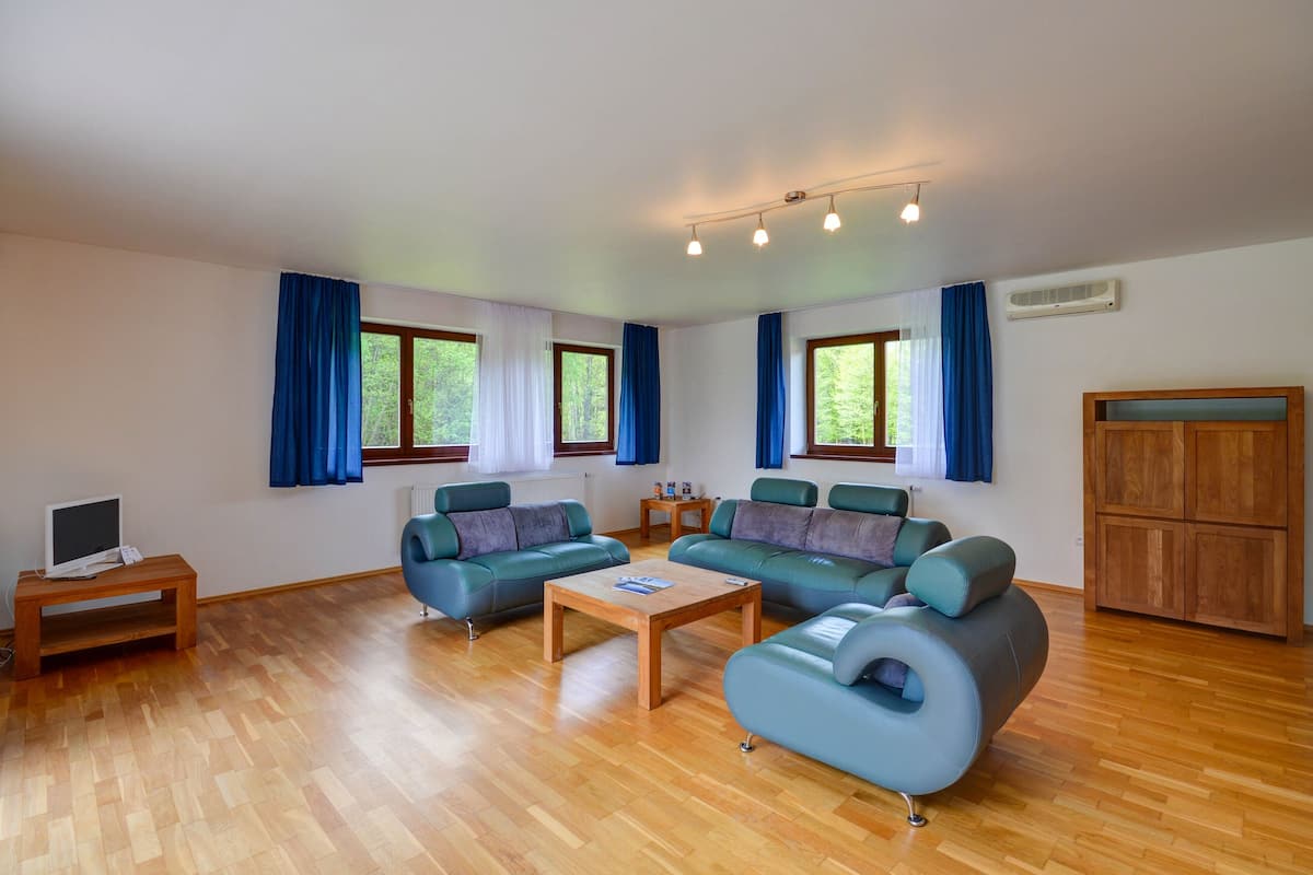 A spacious living room with two sofas, a coffee table, and a TV on a stand.