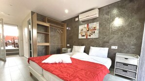 Een moderne slaapkamer met een groot bed, een inbouwkast en een schilderij aan de muur.