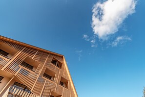 A modern building with a sloped roof and multiple balconies. - Oberhauser Hütte Passion for Nature (Luson)