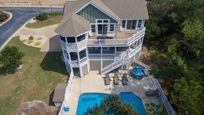 A two-story house with a large deck, a swimming pool, and a fenced yard. - Wood Duck Inn: Dog-friendly, Private Pool, Hot Tub (Corolla)