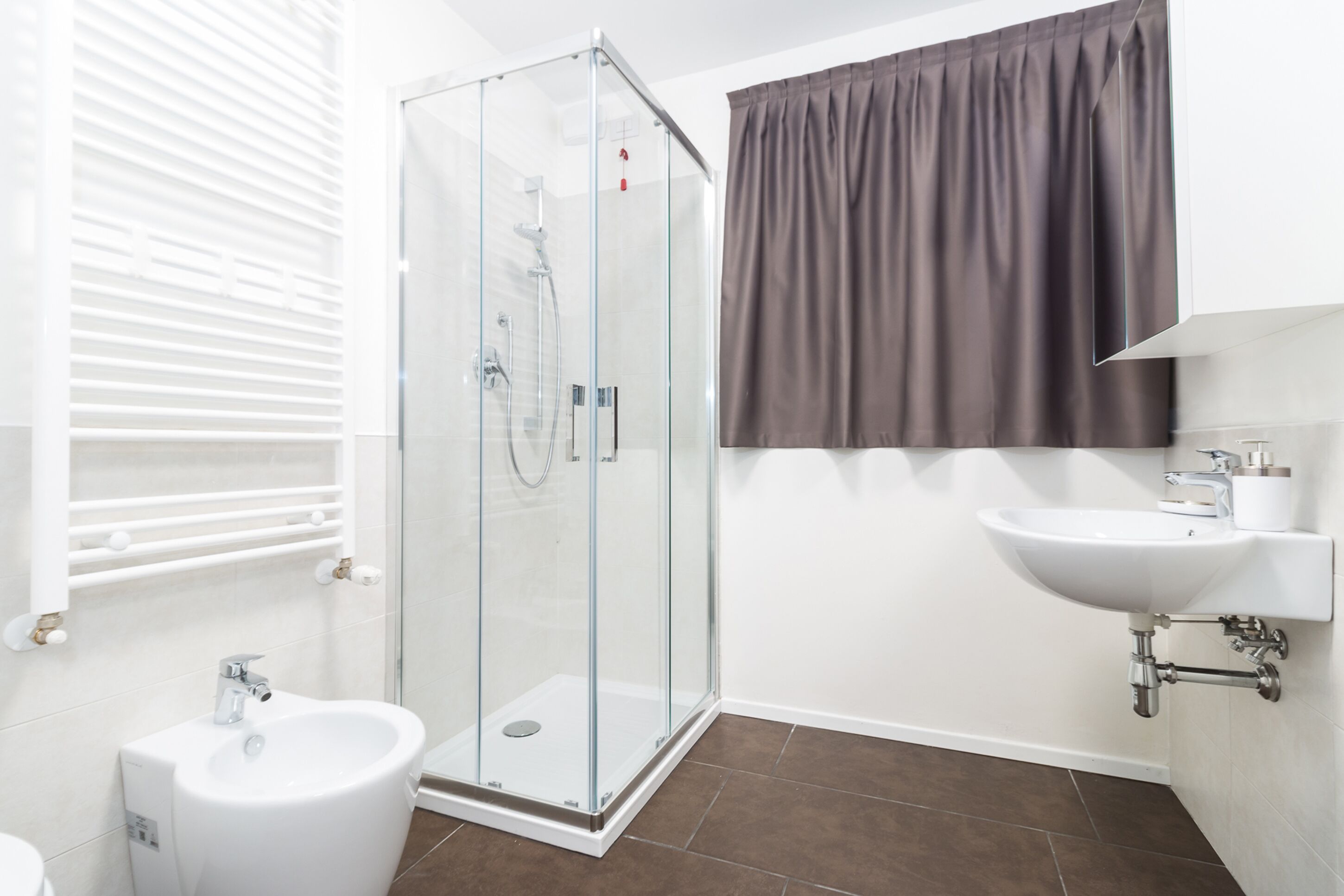 Une salle de bain avec une douche à parois de verre, un lavabo et des toilettes.
