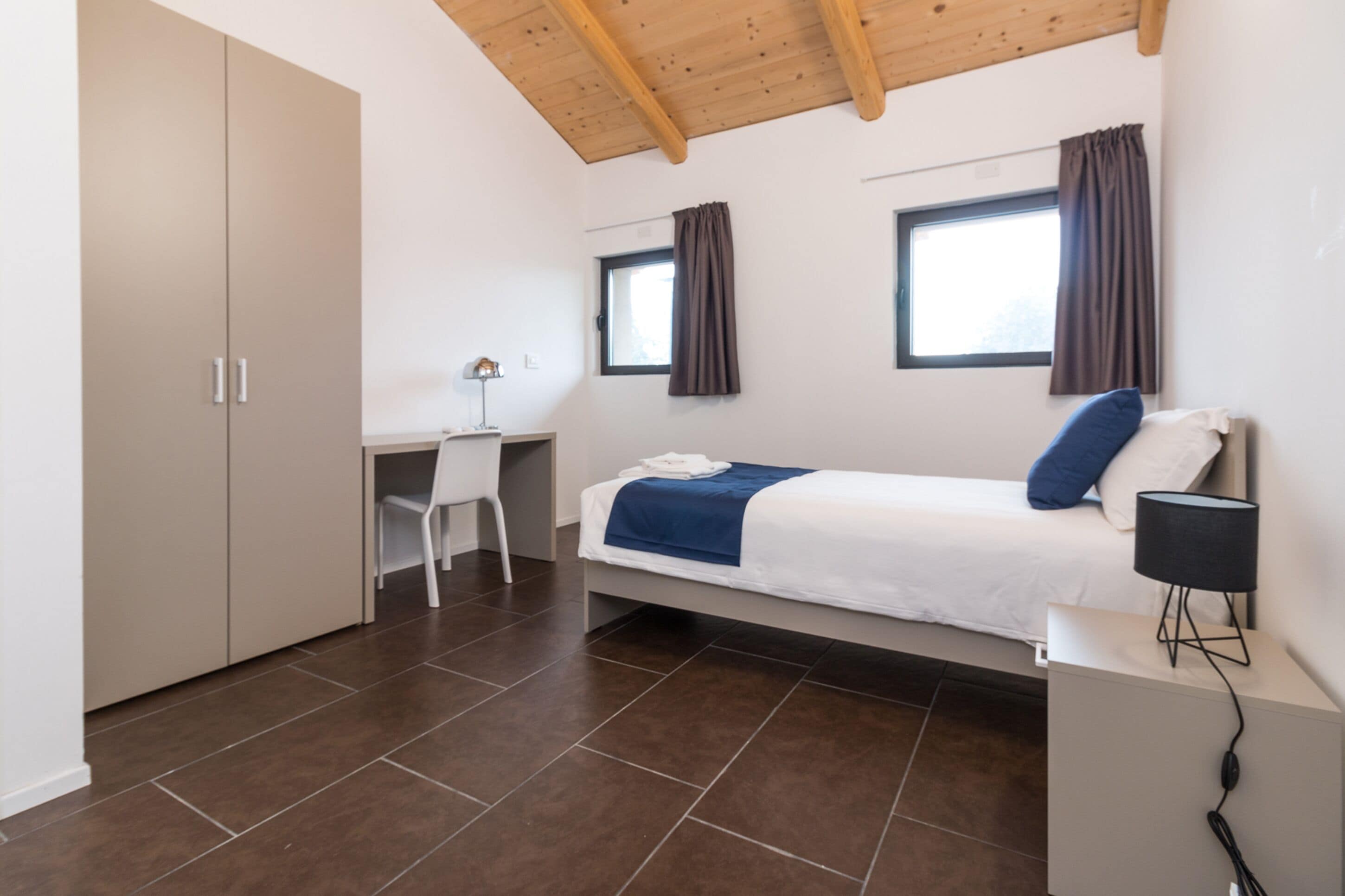 Une chambre à coucher avec un lit, un bureau et une armoire.
