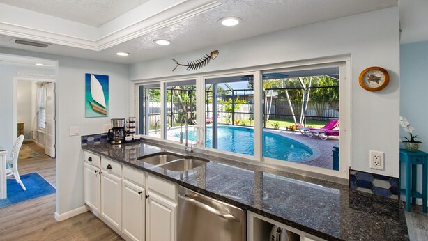 Una cucina moderna con un'ampia finestra che si affaccia su una piscina.