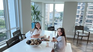 Un espace repas comprenant une grande table, des chaises et un bol rempli de collations.