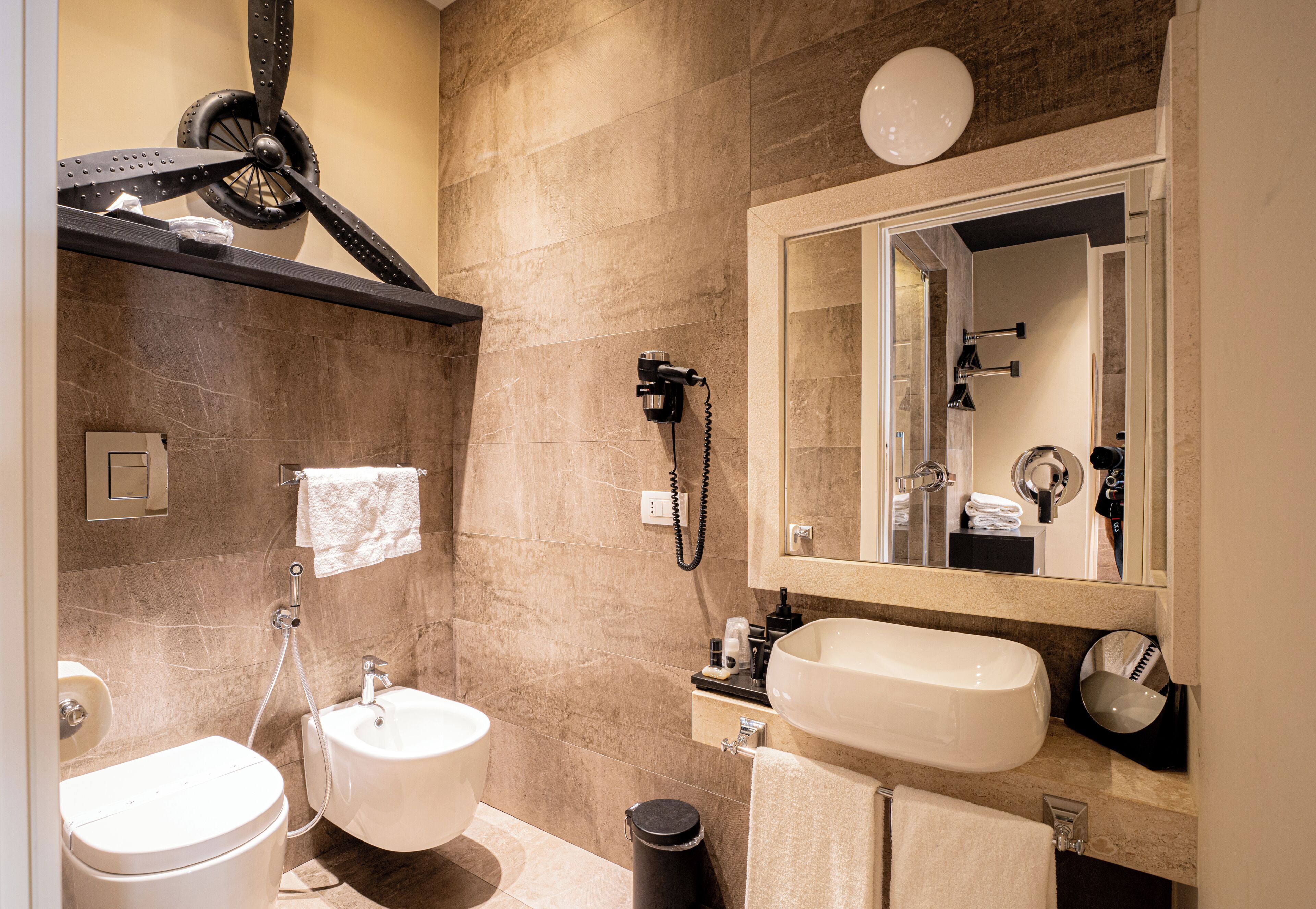 A modern bathroom with a toilet, sink, and mirror.