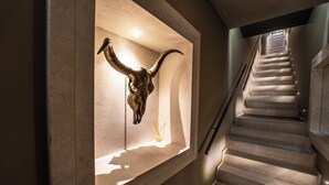 A staircase with a mounted cow skull and a sign reading "SEVEN" at the top. - Neko Boutique Hotel (Cagliari)