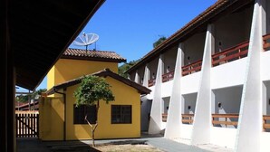 A building with multiple balconies and a yellow building adjacent to it.
