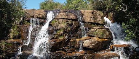 A waterfall cascading over rocky terrain surrounded by dense vegetation.