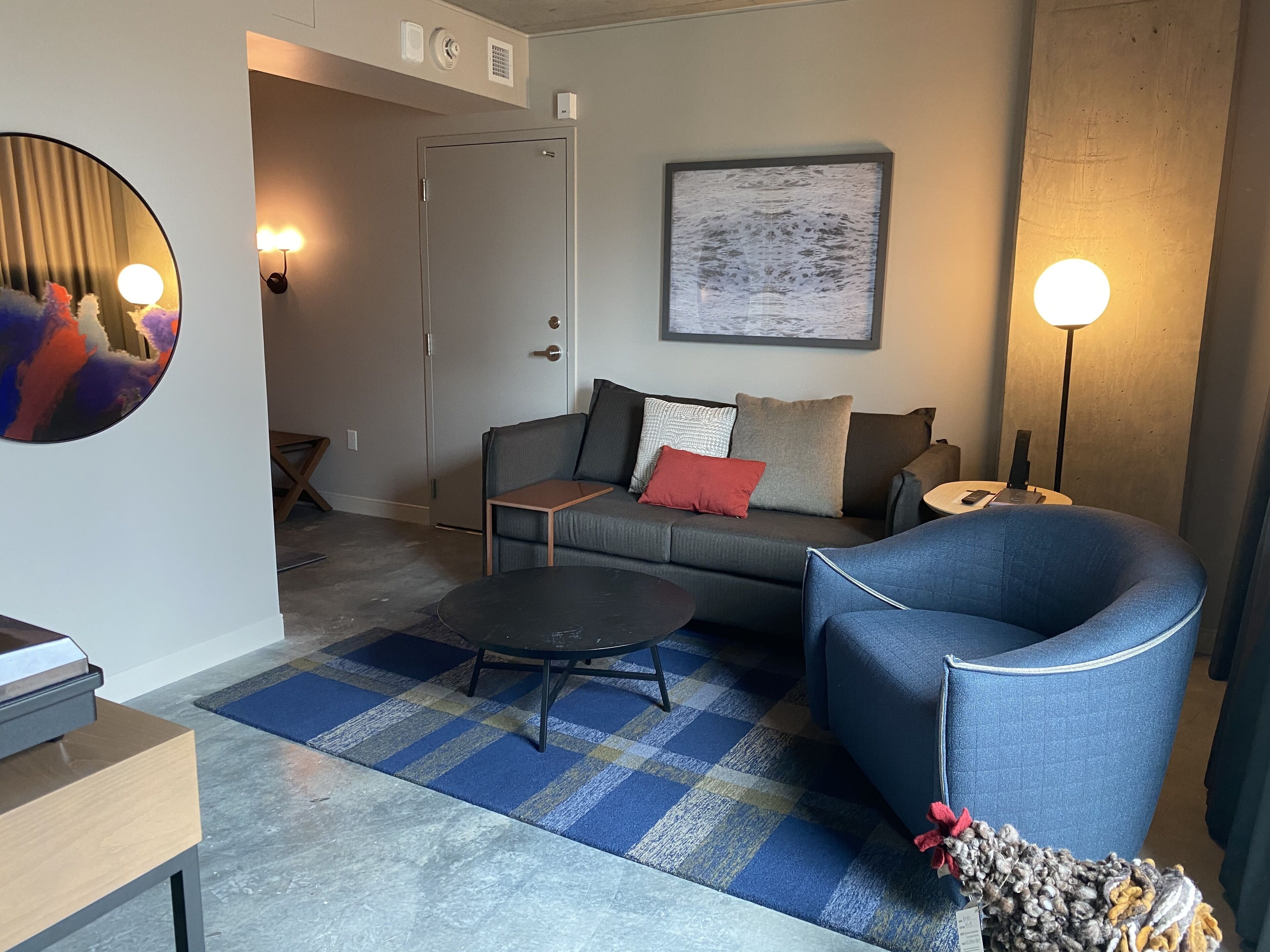 Una sala de estar moderna con sofá, sillón, mesa de centro y alfombra.