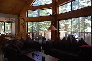Relax in a cabin with a high ceiling, large windows, and a comfortable seating area.
