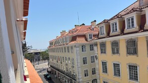 A street view with buildings featuring classic architecture, a clear sky, and a stop sign. - Azulejos Cais Sodré B&B (Lisbon)