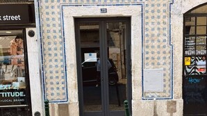 A building facade with a tiled entrance, a visible door, and a small sign above the door. - Azulejos Cais Sodré B&B (Lisbon)