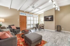 A living room with a sofa, ottoman, and a dining area with chairs and a table. - #B 1-level, 2Bd, 1Block to Beach, Esplanade, Shops (Redondo Beach)