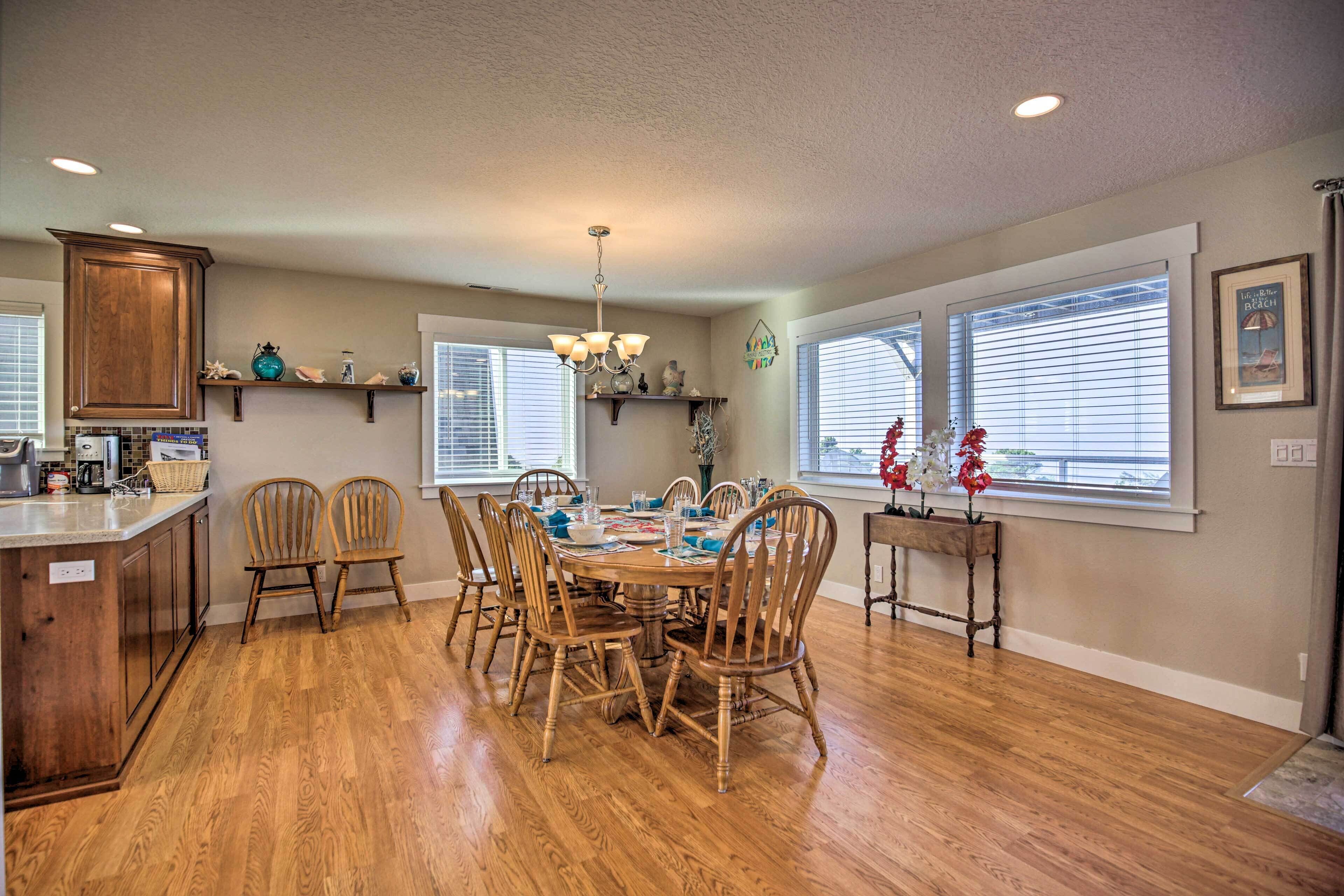 A dining area with a wooden table, chairs, and a chandelier.