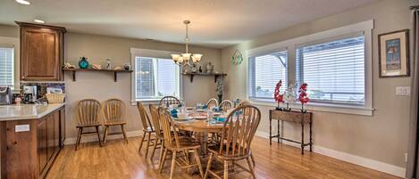 A dining area with a wooden table, chairs, and a chandelier.
