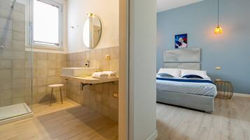 Une salle de bain moderne avec une douche, un lavabo et un miroir.