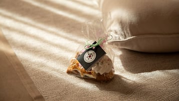 Eine kleine Geschenktüte mit einem Anhänger auf einer strukturierten Stoffoberfläche.