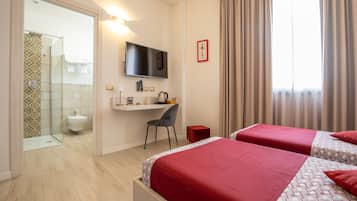 Une chambre d’hôtel avec deux lits, un bureau, une télévision et un espace douche.