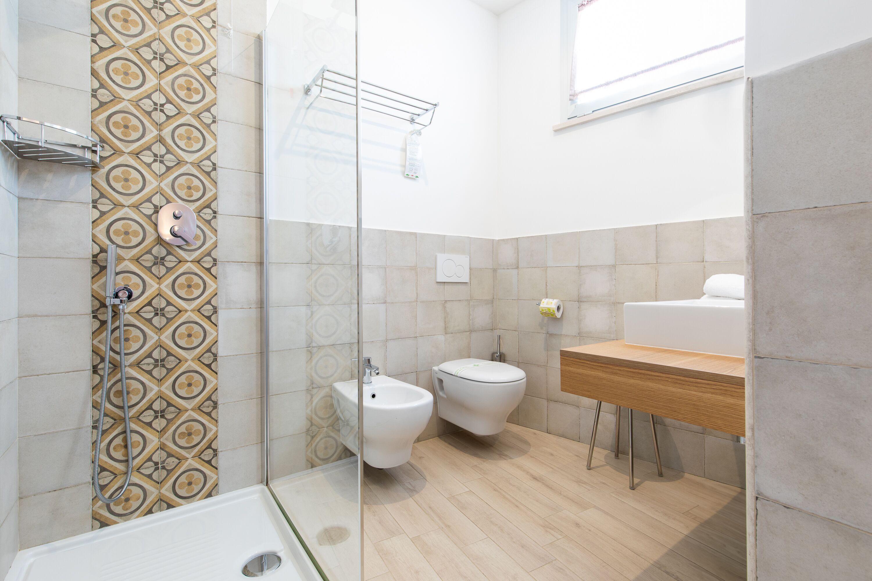 Un baño moderno con ducha, bidé y tocador de madera.