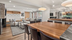 A modern kitchen with a large wooden island, built-in appliances, and a stone accent wall. - Contemporary Condo in Aspen Core (Aspen)