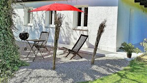 A patio with a grill, two chairs, and a red umbrella. - Large vacation guest apartment Münsing near Lake Starnberg and the Alps 125m² ground floor + first floor (Münsing)