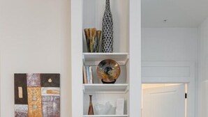 Une cuisine moderne avec des meubles blancs, un plan de travail blanc et un plancher en bois.