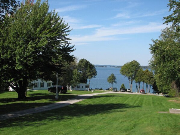 A residential area with a road leading to a body of water, surrounded by trees and houses. - West Winds Motel & Cottages (Clayton)